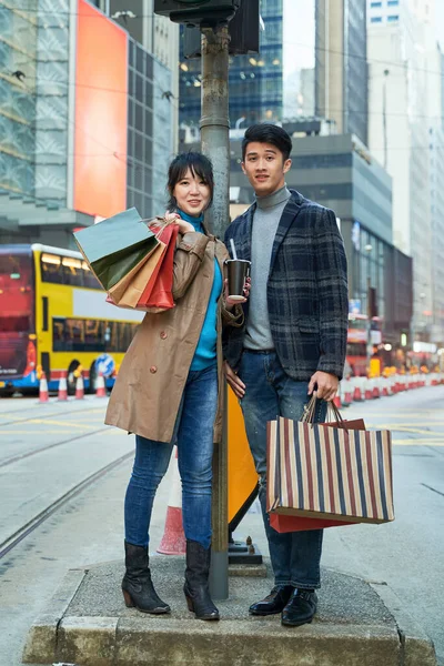 ショッピングバッグを手にした若いアジアのカップルの屋外の肖像画 — ストック写真