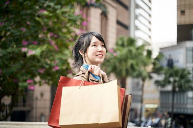 Güzel, mutlu, genç Asyalı alışveriş çantaları taşıyordu.