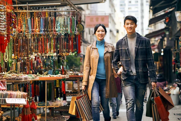 Young Asian Couple Walking Street Commodity Market Carrying Shopping Bags — Stock Photo, Image