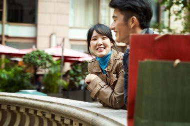 Mutlu genç Asyalı çift dışarıda sohbet ediyor.