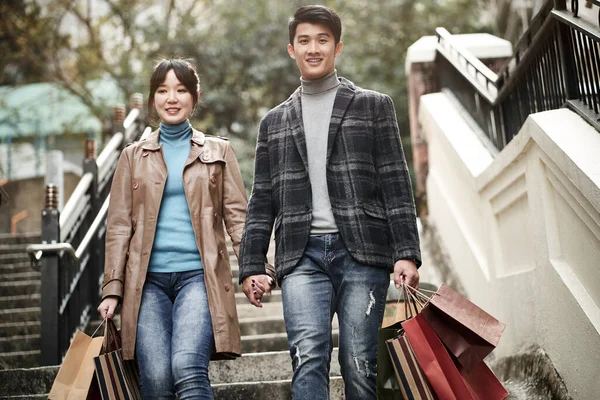 Happy Young Asian Couple Walking Steps Carrying Paper Shopping Bags — Stock Photo, Image