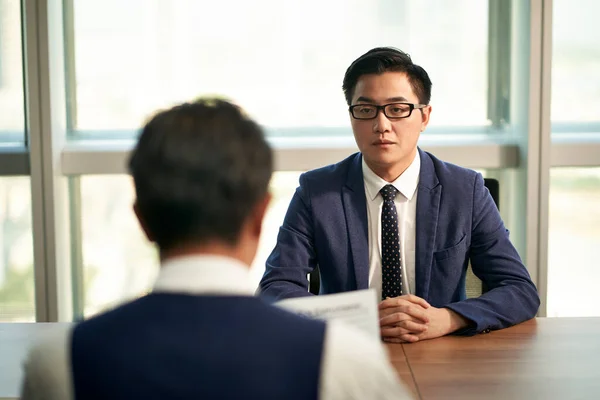 nervous young asian man being interviewed by corporate human resources manager