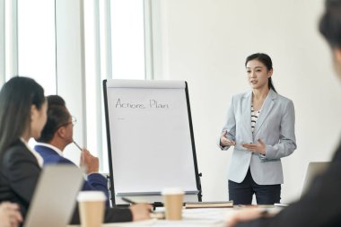 Genç Asyalı iş kadını ofiste takım toplantısı sırasında bir tartışmayı kolaylaştırıyor.