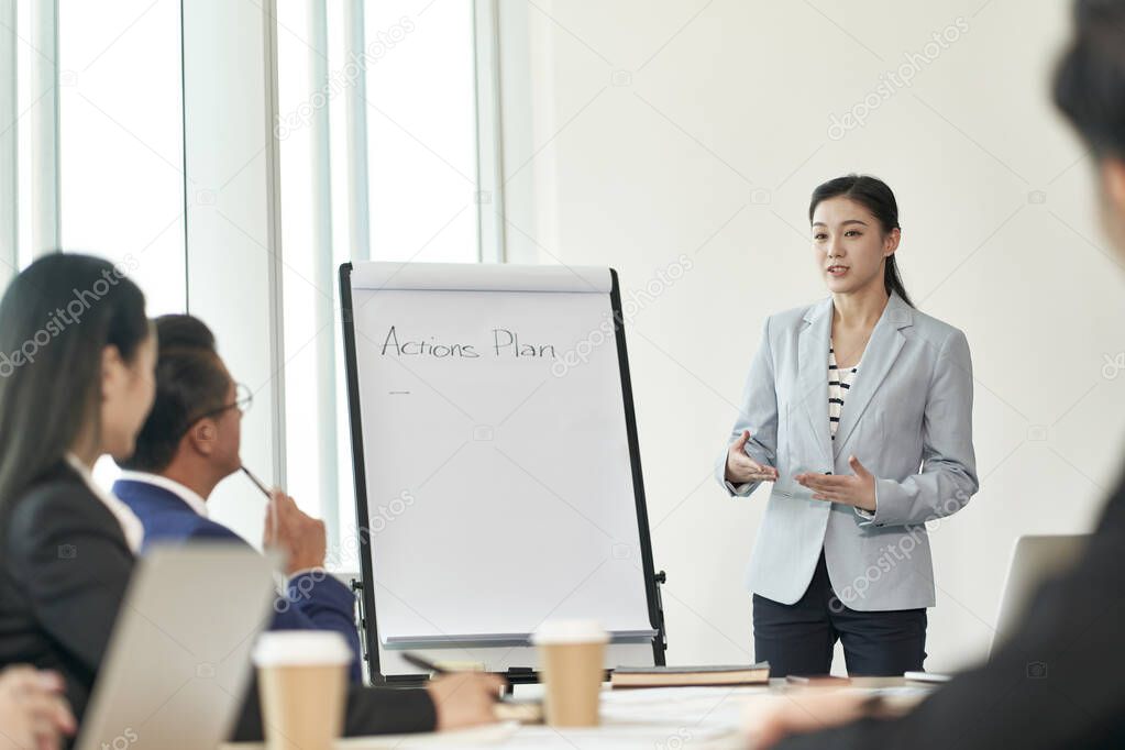 young asian business woman facilitating a discussion during team meeting in office