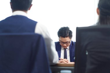 Genç Asyalı iş adamı işe son vermeyi öğrendikten sonra üzgün görünüyor