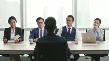 Genç Asyalı iş adamı bir grup İK yöneticisi tarafından sorgulanıyor.