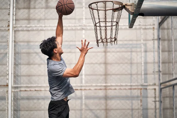 Fiatal Ázsiai Felnőtt Férfi Kosárlabda Játékos Próbál Zsákolni Szabadtéri Pályán — Stock Fotó