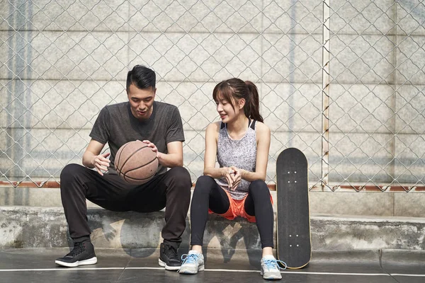 Ung Asiatisk Vuxen Man Basketspelare Och Kvinnlig Skateboardåkare Sitter Planen — Stockfoto