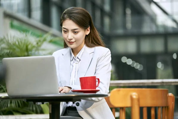 使用笔记本电脑在咖啡店外面工作的年轻亚洲女商人 — 图库照片