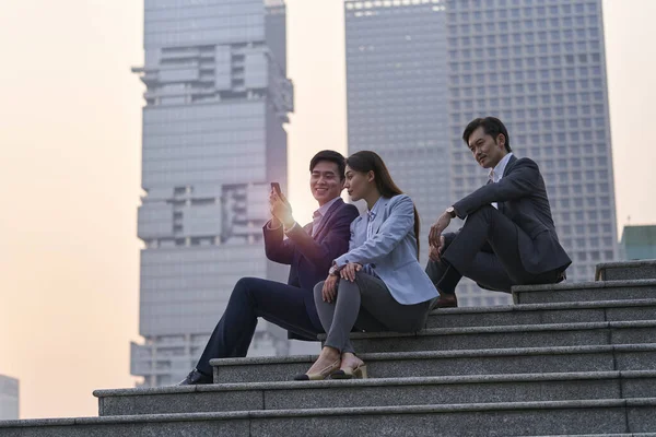 Equipe Três Asiáticos Executivos Corporativos Sentados Passos Olhando Para Telefone — Fotografia de Stock