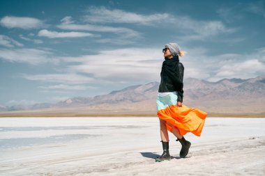 Uzun etekli Asyalı kadın turist. Saline Alkali arazisinde yürüyor.