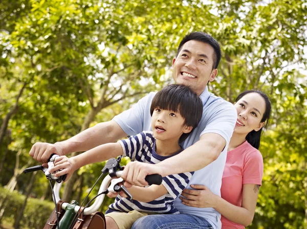 Asiatiska familj ridning cykel i park — Stockfoto