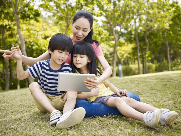 Asya anne ve çocuk tablet bilgisayar kullanarak