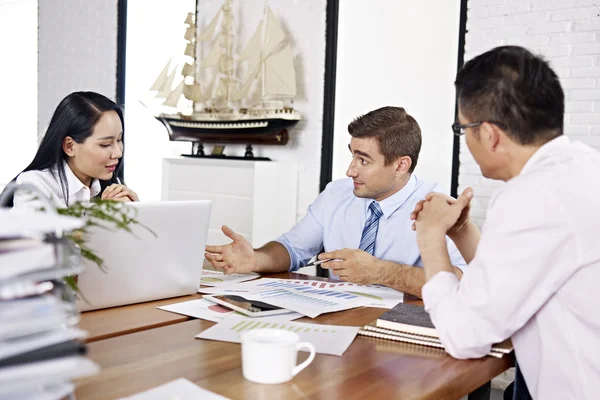 Multinational businesspeople discussing sales performance in office — Stock Photo, Image