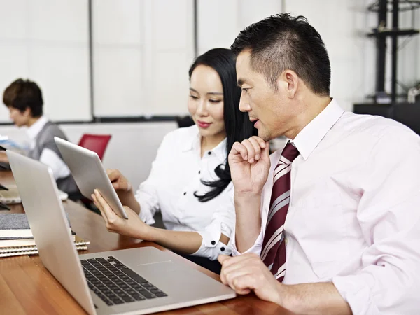 Азиатский бизнесмен и женщина, работающие в офисе — стоковое фото