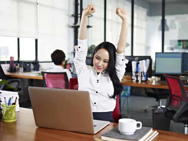 Asian business woman stretching arms in office — Stok fotoğraf