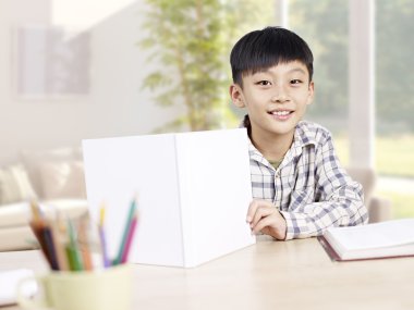 asian schoolboy studying at home clipart