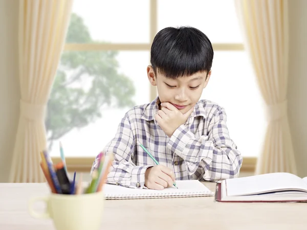 Aziatische schooljongen thuis studeren — Stockfoto