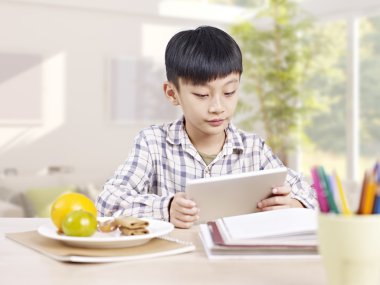 Asyalı çocuk tablet bilgisayar kullanarak