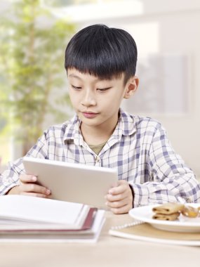 Asyalı çocuk tablet bilgisayar kullanarak