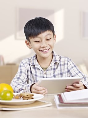 Asyalı çocuk tablet bilgisayar kullanarak