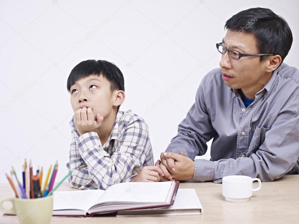 asian father and son having a serious conversation
