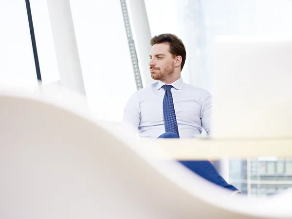 Businessman sitting at desk thinking — Stock Photo, Image