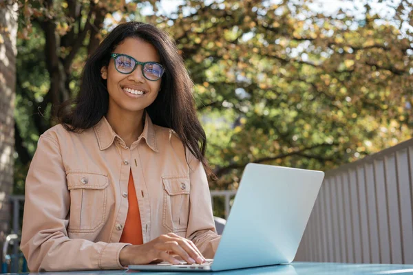 Hermosa Mujer Negocios Afroamericana Utilizando Ordenador Portátil Escribiendo Mirando Cámara —  Fotos de Stock