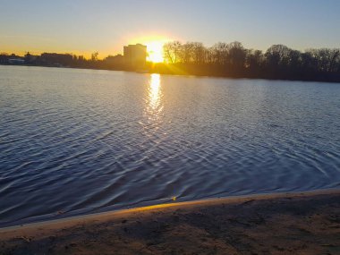 Şehrin ve nehrin arka planında gün batımı