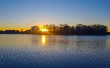 Şehrin ve nehrin arka planında gün batımı