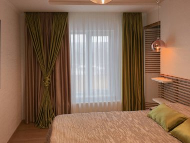 Yatak odası, yatak ve perdeler.