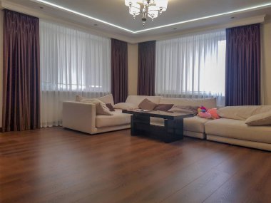 Oturma odasının içinde kanepe ve perdeler var.