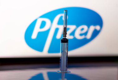 Katmandu, Nepal - 24 Kasım 2020: Pfizer Logosu önünde şırınga enjeksiyonu. Pfizer ve Biyoteknoloji aşıları insan deneyinin 3. aşamasında COVID-19 'a karşı% 94 etkinlik gösterdi..