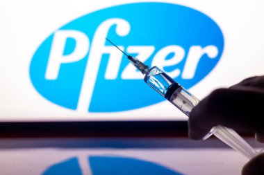 Katmandu, Nepal - 24 Kasım 2020: Pfizer Logosu önünde şırınga enjeksiyonu. Pfizer ve Biyoteknoloji aşıları insan deneyinin 3. aşamasında COVID-19 'a karşı% 94 etkinlik gösterdi..