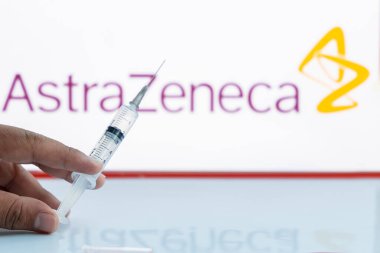 Katmandu, Nepal - 28 Kasım 2020: Adam AstraZeneca Logosuna karşı boş şırınga tutuyor.