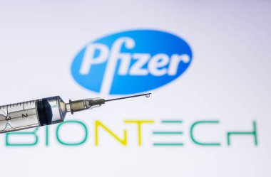 Katmandu, Nepal - 02 Aralık 2020 COVID-19 Aşı Konsepti. Pfizer Biyoteknik logosu önünde aşıyla dolu bir şırınga. Pfizer aşısı dünyada kitle kullanımı için ilk onaylanan aşı oldu..