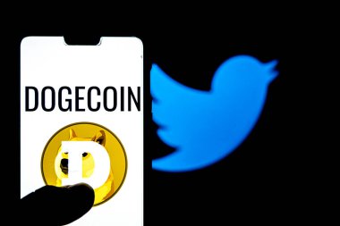 Katmandu, Nepal - 10 Şubat 2021: Arka planda akıllı telefon aganist logosu üzerinde Dogecoin logosu. Dogecoin 'in değeri Elon Musk' un tweet 'inden sonra birden fazla kez arttı..