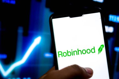 Katmandu, Nepal - 10 Şubat 2021: Arkaplandaki borsa grafiğinde Robinhood uygulama logosuna sahip adam akıllı telefonu elinde tutuyor.
