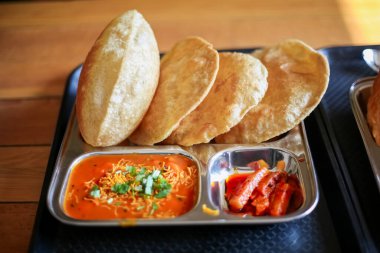 Puri Sabji veya Poori Sabzi. Hint yemeği. Baharatlı sebze ve baharatlı turşuyla servis edilen Hint usulü kızarmış ekmek. Lezzetli görünen Hint yemekleri. Bu tür atıştırmalıklar Hint alt kıtasında popülerdir..