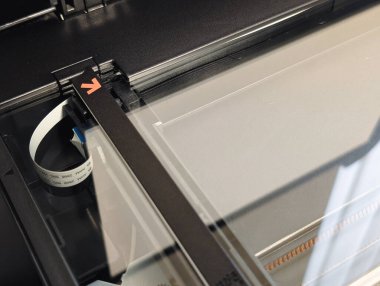 close-up of a blank glass flatbed scanner with arrow indicator