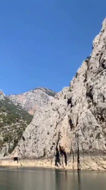 Mavi gökyüzünün altında hindi içinde görkemli yeşil kanyonda düşey tekne turu.