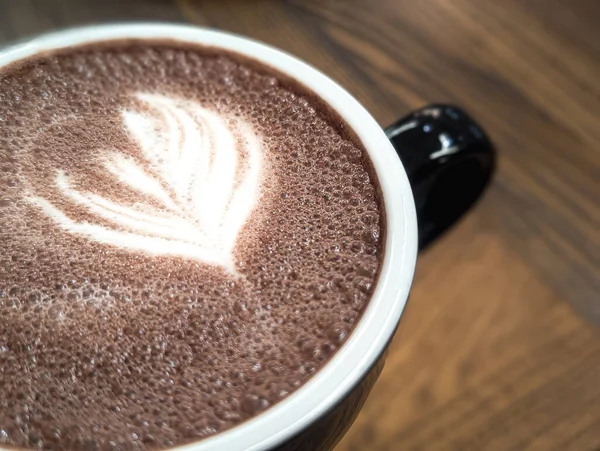 Tahta masada köpüklü kakao içeceği. Yakın çekim.