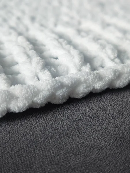 Koyu gri kabataslak arkaplan üzerine yumuşak beyaz tıknaz örgü kumaş kenarlığını kapat
