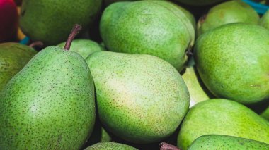 Detaylı deri dokusunu gösteren taze yeşil armut yığınını kapat.