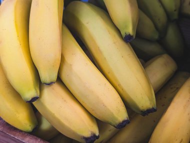 Tahta bir sandığa doldurulmuş yeşil uçlu olgun sarı muzları kapatın.