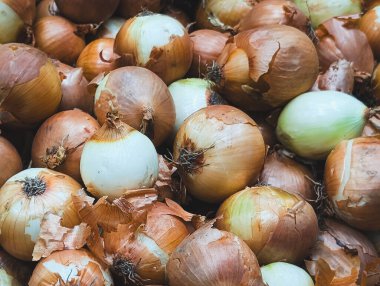 Pazarda kağıt kabuklu taze sarı soğan yığını.