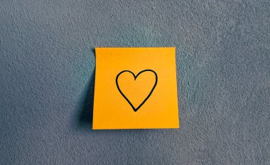 Turuncu bir nota elle çizilmiş kalp sembolü.