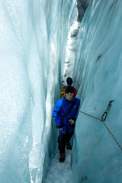 Junger Mann wandert zwischen Gletscherspalten auf dem Franz-Josef-Gletscher, Neuseeland, Südinsel — Stockfoto