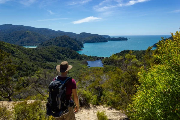 Young man enyoing panoramic view of a tropical beach with turquoise water and white sand in abel tasman national park, new zealand — Stock Photo, Image