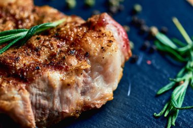 Makrofonlu domuz bifteği ve domuz yağı, ahşap bir tahtanın üzerinde sarımsak, biberiye, tuz ve biber ile birlikte duruyor. Et çok lezzetli. Çok fazla yağ..